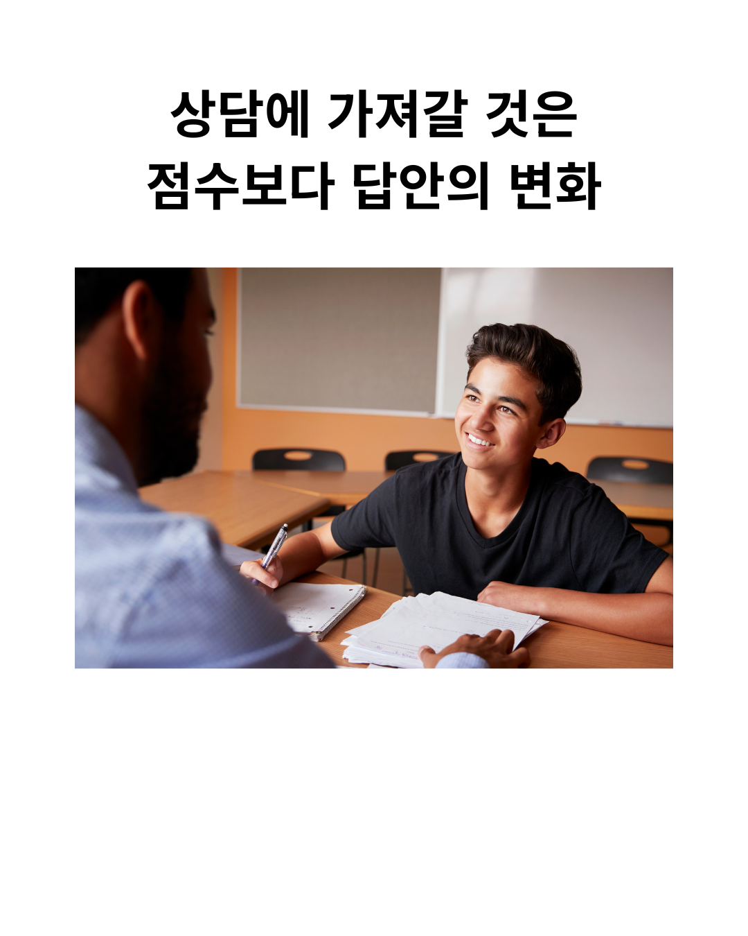 교습자가 학생과 책상에서 학습지를 함께 살펴보는 스톡 사진.